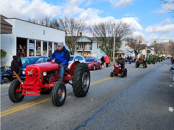man driving a red tractor in a parade