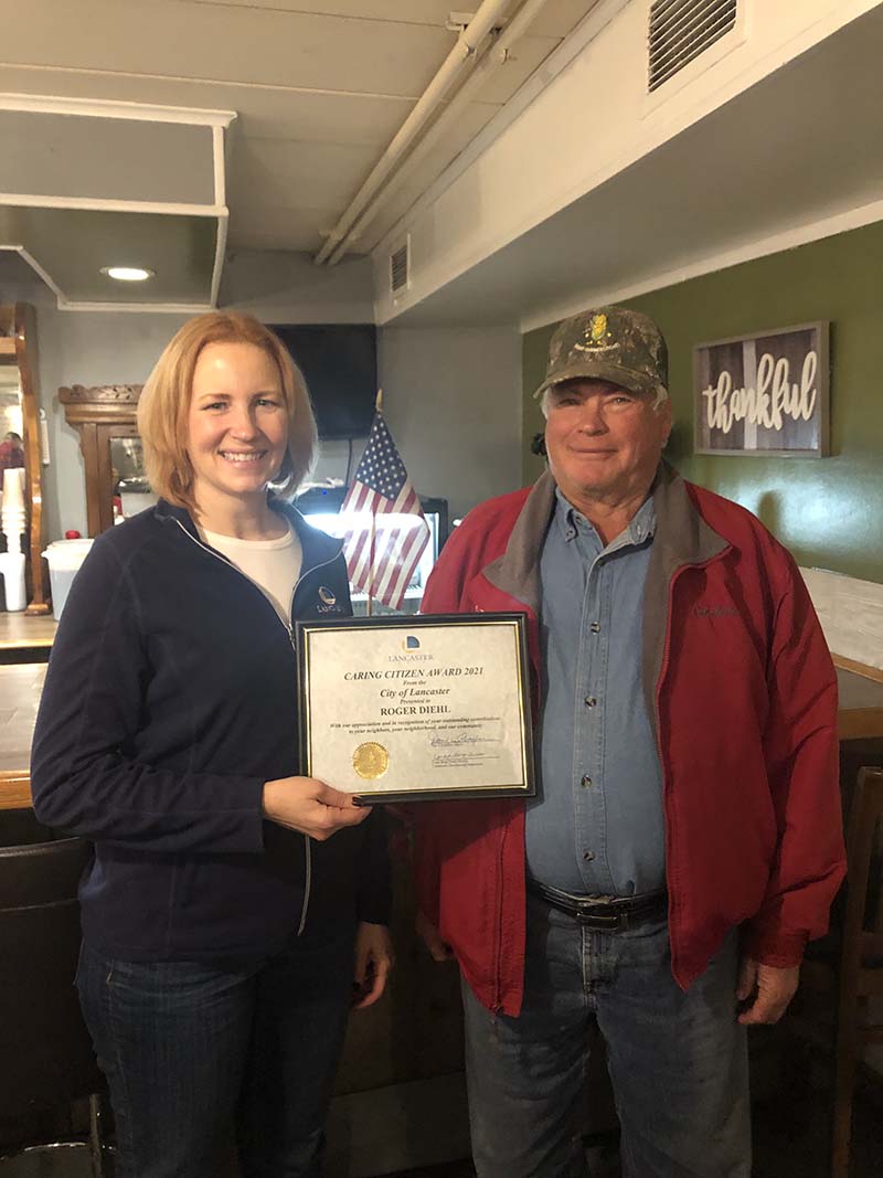 Lynda Disser presenting Roger Diehl with the City of Lancaster Caring Citizen Award certificate