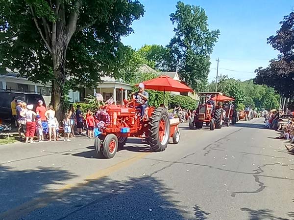 red tractors being driven in a parade